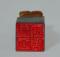 The Seal: A fine carved Soapstone seal, with a small figure guiding a sampan through stormy seas with crested waves, beneath a towering rocky cliff, with a gnarled tree clinging to the edge of tiered rockwork, inscribed Meng Yan xing shang.