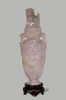 A carved Jadeite lavender vase, with loose ring handles, decorated in relief with a continuous design of dragon and clouds. The cover carved as a dog of fo.