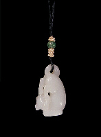 Reverse: Nephrite pendant, mutton fat, carved in the form of a reclining dog with one rear paw in its mouth, its tail looped over onto its back to form the suspension area for the pendant.