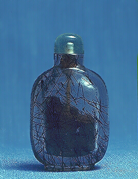 A quartz crystal, with black tourmaline needles, plain ladies snuff bottle with an aquamarine stopper. 