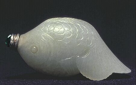 A muttonfat nephrite snuff bottle carved in the form of a carp, the tail provides a built in dish. A glass and metal stopper.