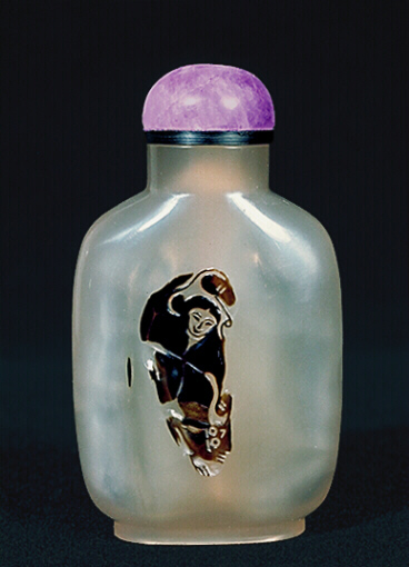 A chalcedony well hollowed silhouette Liu Haii picture snuff bottle with an amethyst stopper. 