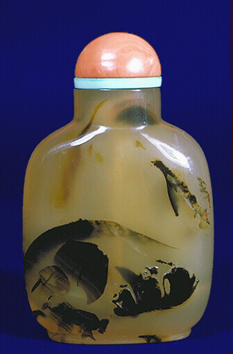 A chalcedony well hollowed silhouette sampan and boulders picture snuff bottle with a coral and turquoise stopper. 