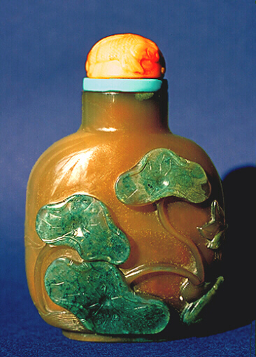 A chalcedony well hollowed cameo toad and lotus carved picture snuff bottle with a coral and turquoise stopper. 