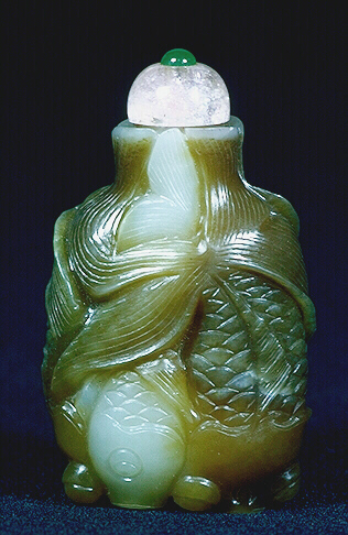 Nephrite snuff bottle, pale celadon and olive green cleverly used in the formation of two pairs of intertwined fish, each pair with one light and one dark fish, their fins, gills, eyes and mouths realistically represented.