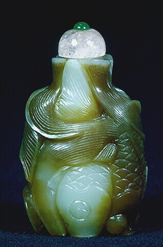 Reverse: Nephrite snuff bottle, pale celadon and olive green cleverly used in the formation of two pairs of intertwined fish, each pair with one light and one dark fish, their fins, gills, eyes and mouths realistically represented.