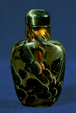 A mottled glass snuff bottle, pale yellow glass with patches of pale brown, grey and black throughout, probably made to imitate tortoiseshell.