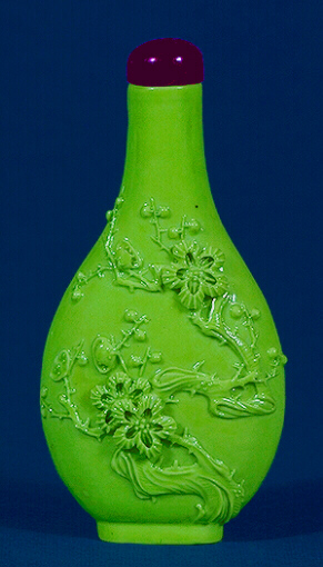 Porcelain, carved in high relief with a raised gnarled Prunus with two central flowers surrounded with unopened buds, all covered in a lime green glaze, the base signed Wang Bingrong.