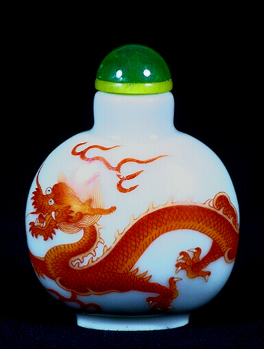 Porcelain snuff bottle, painted in rouge de fer with a rampant scaly dragon chasing a flaming pearl painted in gold enamel, the base inscribed with the mark Doaguang nianzhi.