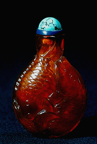 Amber snuff bottle, translucent honey colour carved as two pairs of intertwined fish whose fins unite at the mouth to receive the stopper; their fins, gill, eyes and mouths realistically represented.