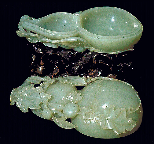 Showing the inside: large pale celadon jade stone.  Carved as a double gourd box, surrounded by foliage, and young gourds.