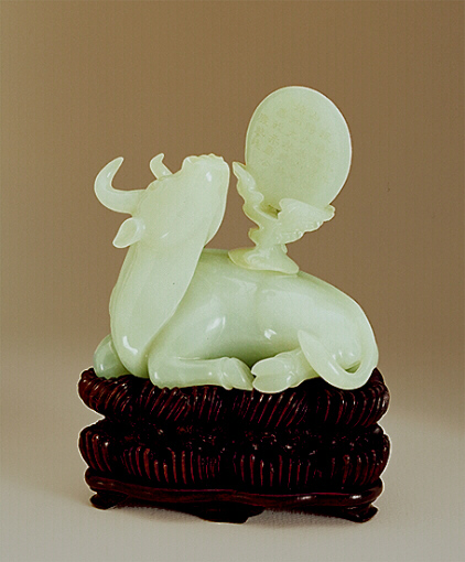 A fine pale celadon jade water dropper figure of a reclining oxen with a cover carved as clouds and the moon that is inscribed with a poem.