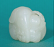 Very white nephrite carving of an elephant resting with its body curled around a small boy reaching up to tickle the elephant's ear with a spray of lingzhi fungus. This is a fine small handling piece, about the size of the average netsuke.