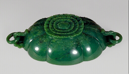 Showing the Base: An even spinage green nephrite bowl, with black flecks, carved as a bowl with loose ring handles and a chrysanthemum style base.