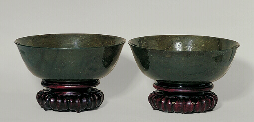 A pair of spinach green nephrite bowls with a seal inscribed on the base.