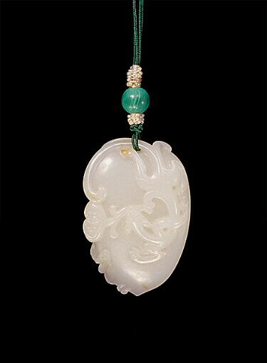 White nephrite pendant carved in the form of a shield with a curling chilong with lingzhi in its mouth and another baby dragon clambering to the side.