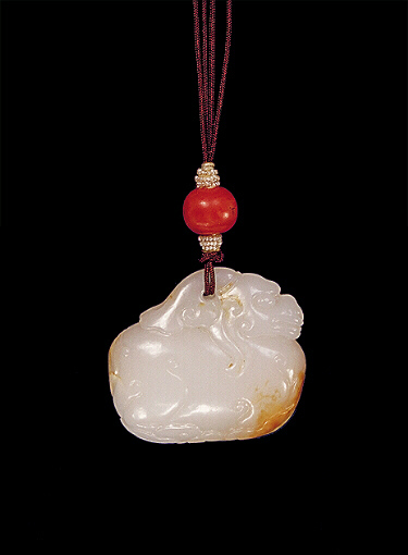 Nephrite pendant, white mutton fat with brown russet areas, carved with a plump, archaic style camel faced beast.