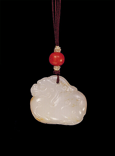 Reverse: Nephrite pendant, white mutton fat with brown russet areas, carved with a plump, archaic style camel faced beast.