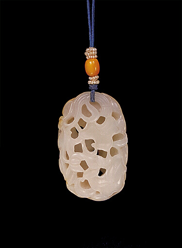 Nephrite pendant, a pebble with russet brown skin, the body of white mutton fat pierced and carved with lotus flowers, leaves, stalks and buds.