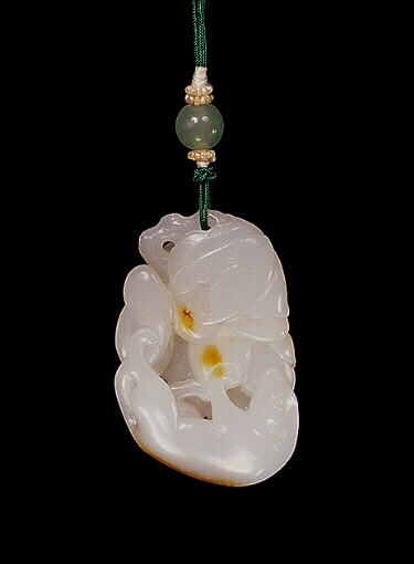 Nephrite pendant, mutton fat and russet carved and pierced with a large squirrel at the lower half of the pendant with a grape between its feet, its tail swept up towards the vine leaves.