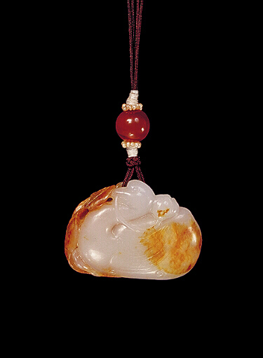 Nephrite pendant, russet brown and white, carved with a duck, its wings swept up with lotus and millet, and leaves on the other side.