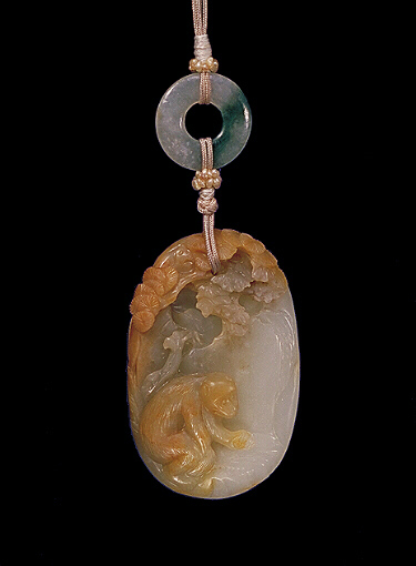 Nephrite pendant, pale grey, with slightly browner skin, with a monkey against a rocky landscape holding his prize gained from the trees above, the reverse with craggy rock work. Suzhou School.