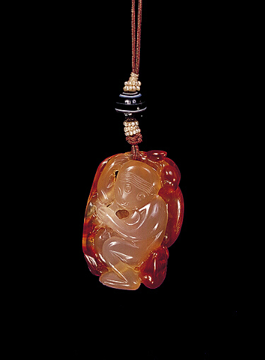 Chalcedony pendant, pale translucent beige with ginger russet areas carved with a monkey and a peach. The other side with the ginger colour carved as a monkey, with two peaches on a branch.