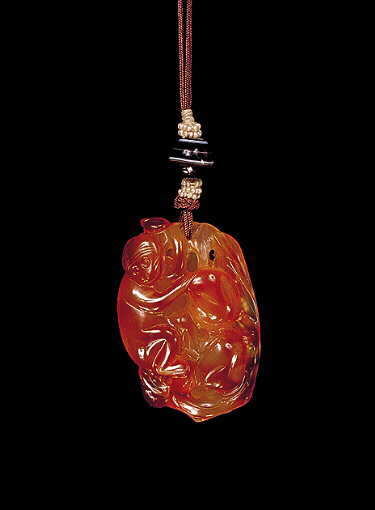 Reverse: Chalcedony pendant, pale translucent beige with ginger russet areas carved with a monkey and a peach. The other side with the ginger colour carved as a monkey, with two peaches on a branch.