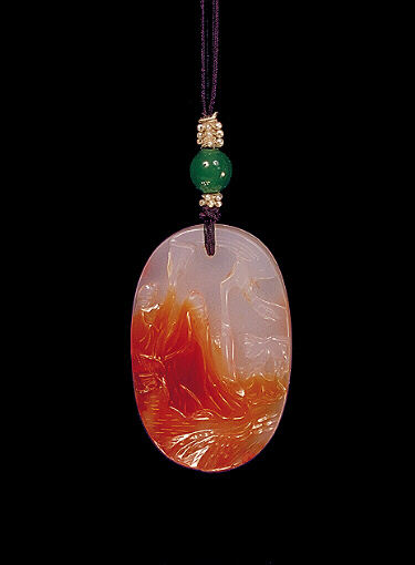 Chalcedony pendant, pale milky colour with orange inclusions carved with an immortal in the rocks with his attendant who holds a fan, the other side with a monkey in a rocky landscape and waterfalls.