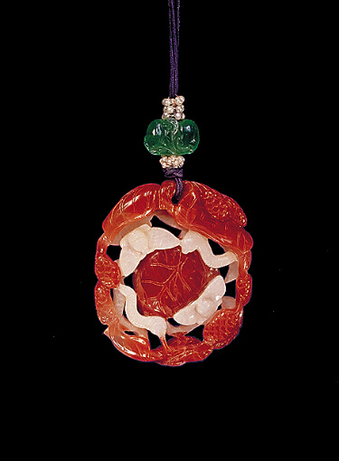 Reverse: Carnelian pendant, pale creamy white with bright, orange veins, the central white area carved with moths and silk worms, centring around mulberry leaves and fruit, the outside carved with leaves and mulberry fruit.