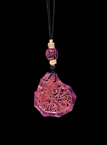 Reverse: Pink tourmaline pendant, carved in an irregular form with the outline of bamboo surrounding peach sprays and branches.