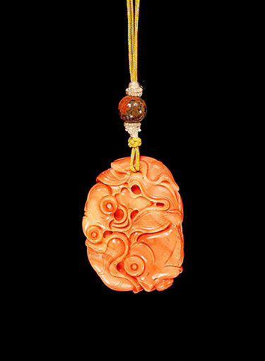 Coral pendant, pale and darker coloured material, carved with two bug-eyed, fan- tailed carp amongst lotus leaves.