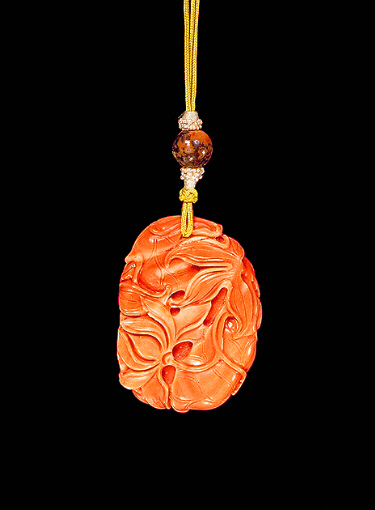 Coral pendant, pale and darker coloured material, carved with two bug-eyed, fan- tailed carp amongst lotus leaves.