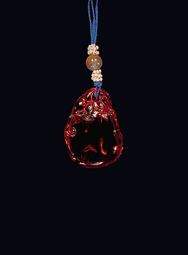 Reverse: Amber pendant of pure, clear, translucent golden colour in the form of a flaming pearl with a dragon draped around it, its head coming over the top in pursuit of ruyi fungus.