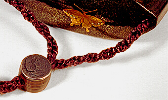 Top: Inro decorated in gold and silver with Shishi and dragonfly, with a drum shaped copper ojime.