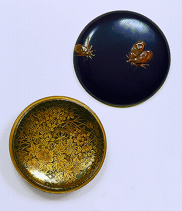 A small round black Kogo with three flying insects, in mottled brown takamakie, inside are a mass of autumn flowers in gold and silver togidashi.