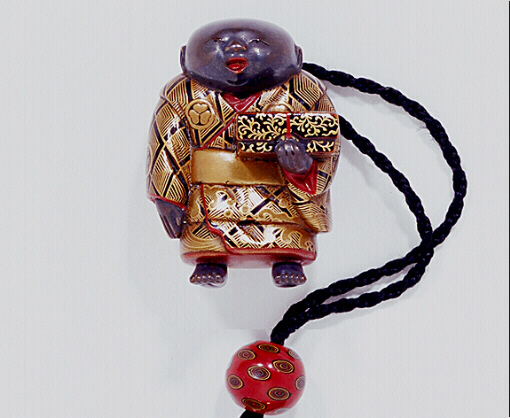 Lacquer netsuke of a boy holding a box